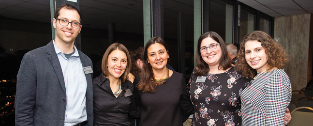 Four women and a man pose at Boston's holiday reception